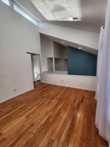 a view of empty room with wooden floor