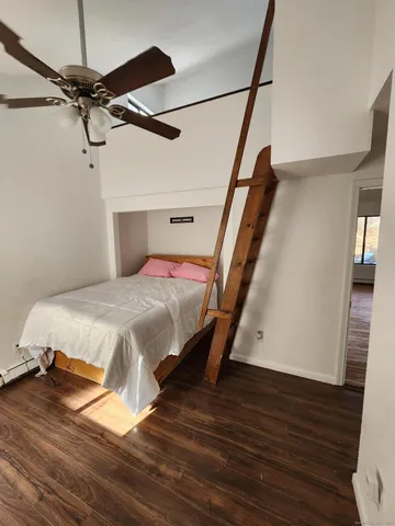 a bedroom with a bed and wooden floor