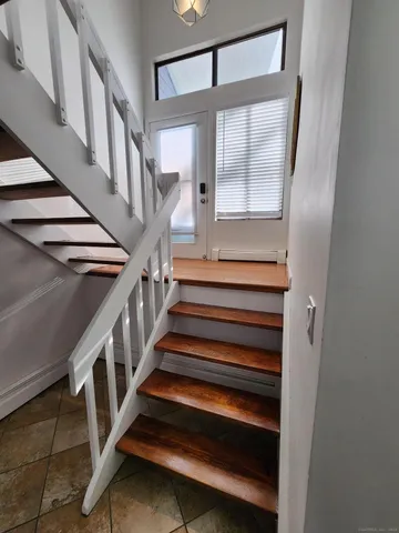 a view of staircase with lots of wooden floor and white walls