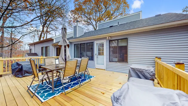 a view of a patio with table and chairs with wooden floor and fence