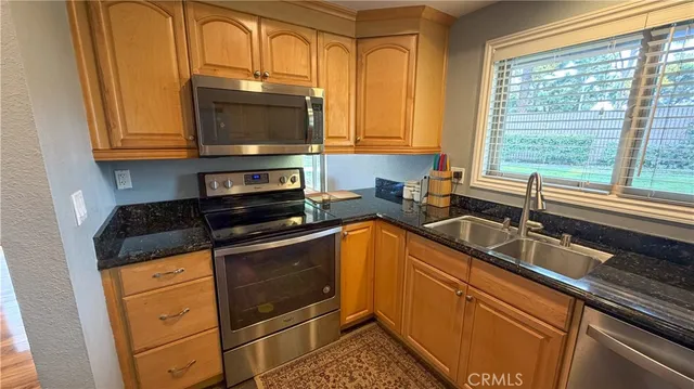 a kitchen with stainless steel appliances granite countertop a sink stove and microwave