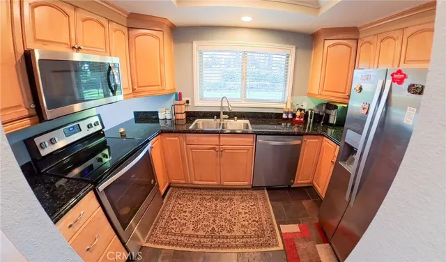 a kitchen with stainless steel appliances granite countertop a stove a sink and a microwave