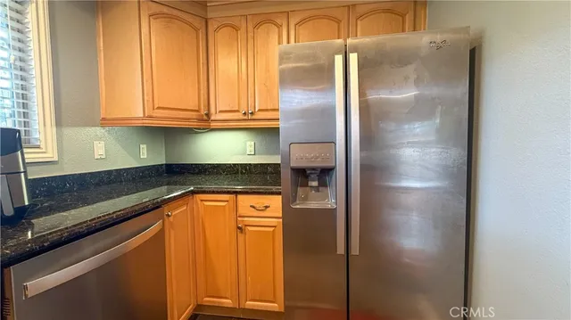 a kitchen with stainless steel appliances granite countertop a refrigerator and a sink