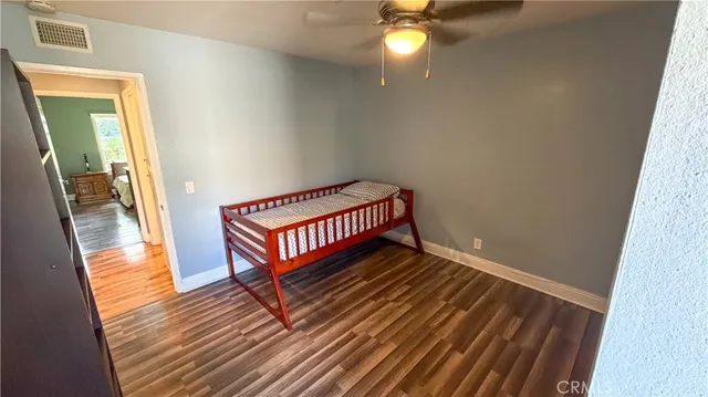 a view of a room with wooden floor and a ceiling fan