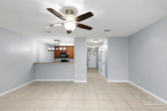 en empty room with wooden floor and ceiling fan
