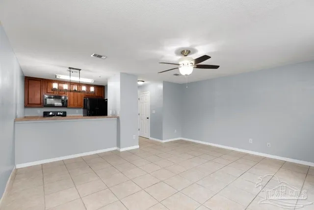 a view of an empty room and a kitchen