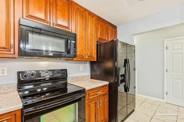 a kitchen with granite countertop a refrigerator stove and microwave