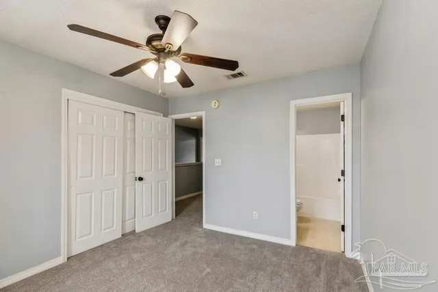 a view of an empty room and chandelier fan