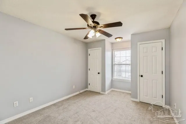an empty room with closet and windows
