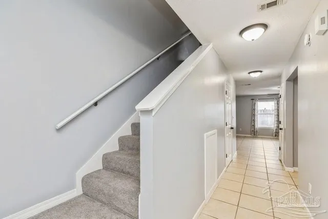 a view of a hallway with white walls and stairs
