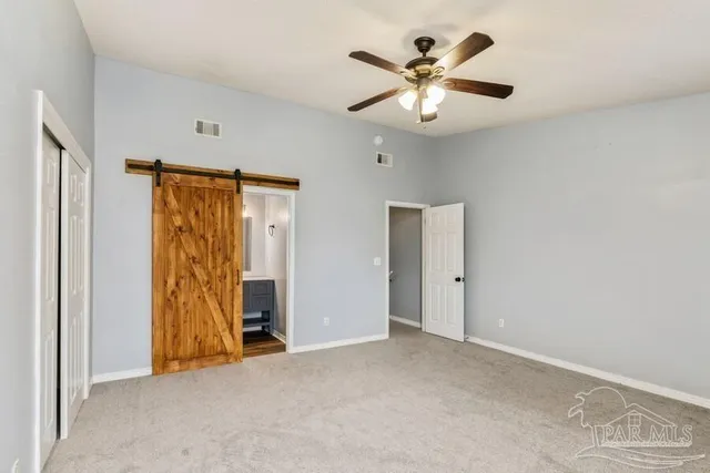an empty room with closet and a ceiling fan