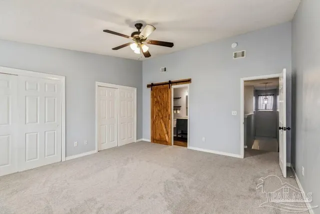 a view of an empty room with a chandelier fan