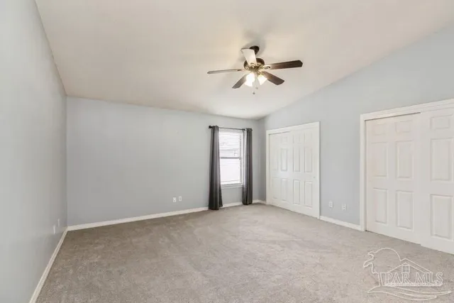 a view of a big room with chandelier fan and windows