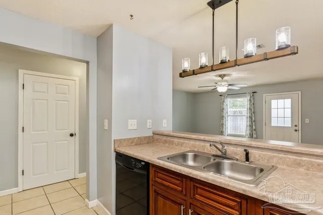a kitchen with kitchen island granite countertop a sink a counter space and stainless steel appliances