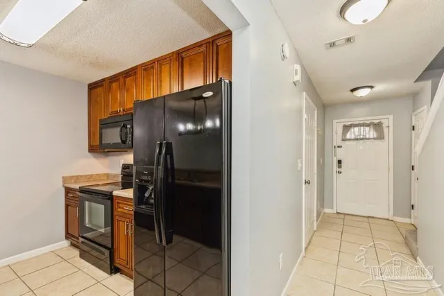 a kitchen with stainless steel appliances granite countertop a refrigerator and a stove