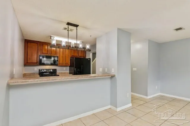 a view of a kitchen with kitchen island and stainless steel appliances