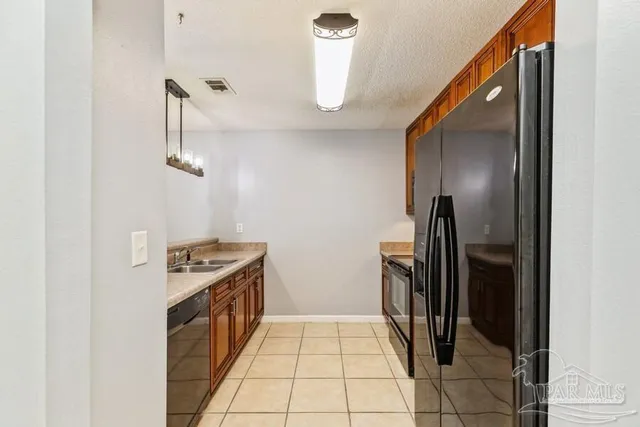 a kitchen with a stove top oven and refrigerator