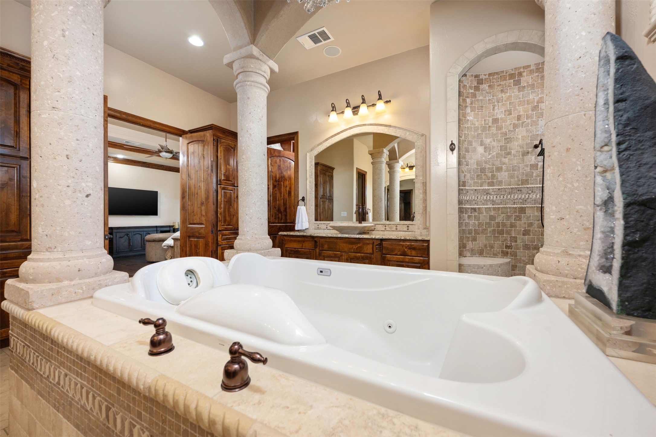 101 Hopewell Circle Georgetown, TX 78628 - Photo 14 of 38 Bathroom with decorative columns, a walk in shower, a jetted tub, and vanity