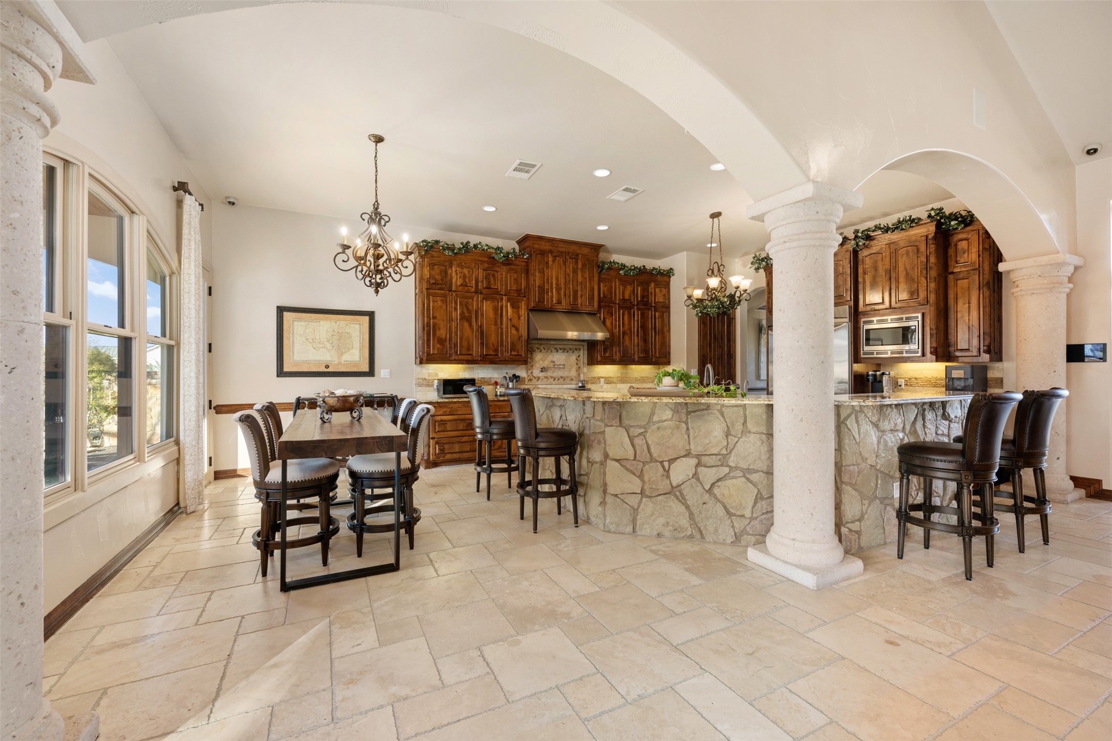 101 Hopewell Circle Georgetown, TX 78628 - Photo 8 of 38 Dining area featuring decorative columns, suspended lighting, stone tile flooring, and arched walkways