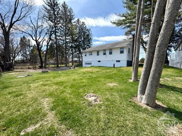 a view of a house with a yard and trees