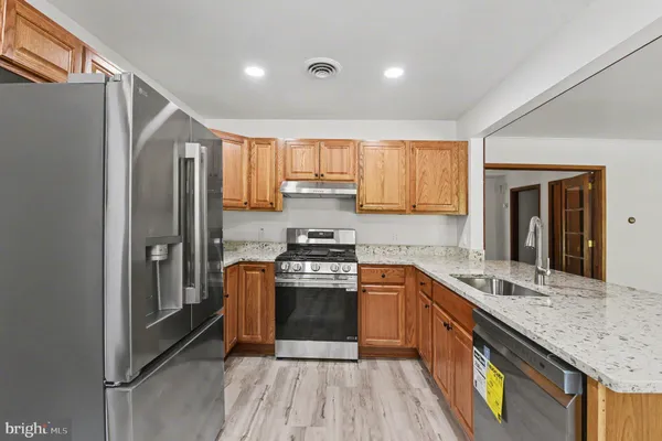 a kitchen with stainless steel appliances granite countertop a stove a sink and a refrigerator