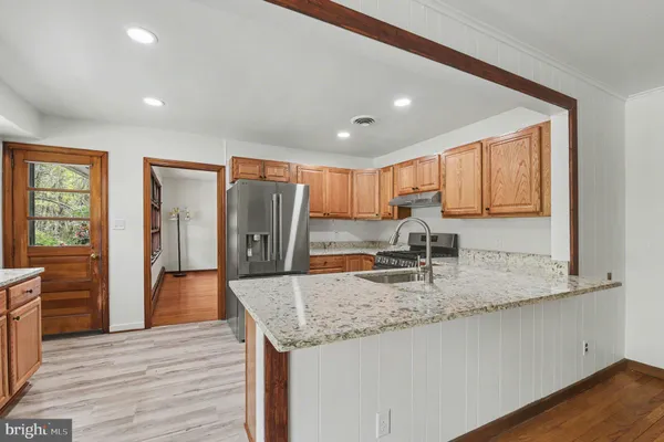 a kitchen with stainless steel appliances granite countertop wooden floors and granite counter tops