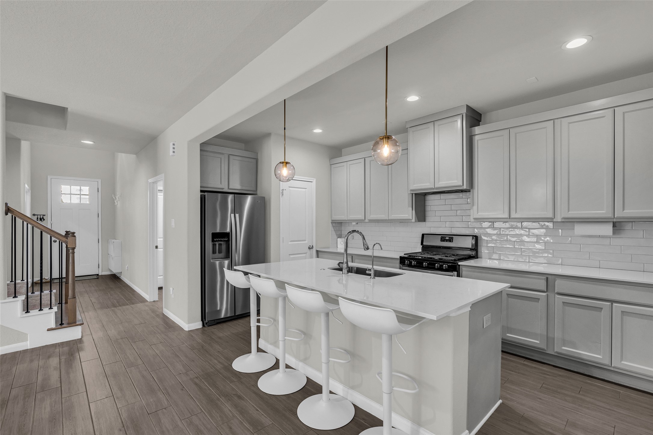 2344 Hagerman Road Conroe, TX 77384 - Photo 4 of 27 Modern kitchen featuring sleek cabinetry, stainless steel appliances, and a spacious island with stylish pendant lighting, ideal for entertaining and family gatherings.