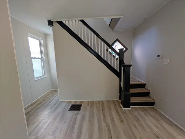 a view of entryway and hall with wooden floor