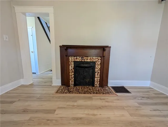 a view of empty room with wooden floor and fireplace