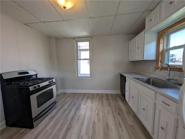 a kitchen with granite countertop wooden floors and white stainless steel appliances