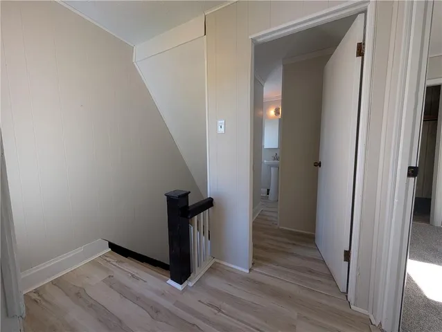 a view of a hallway with wooden floor and staircase