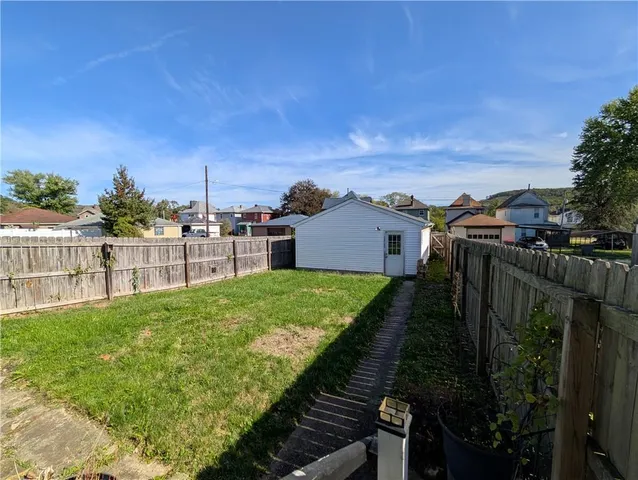 a view of a backyard with wooden fence