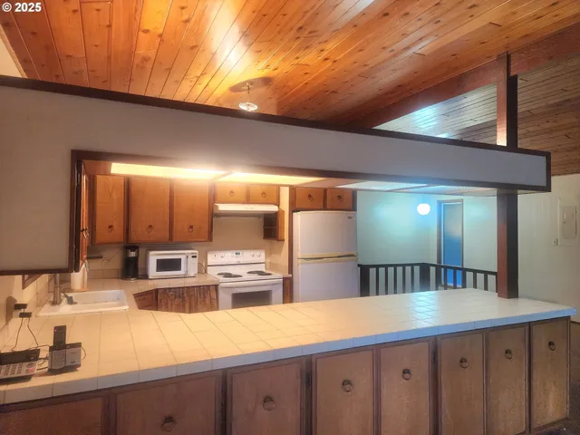 a kitchen with stainless steel appliances granite countertop a sink a stove and refrigerator