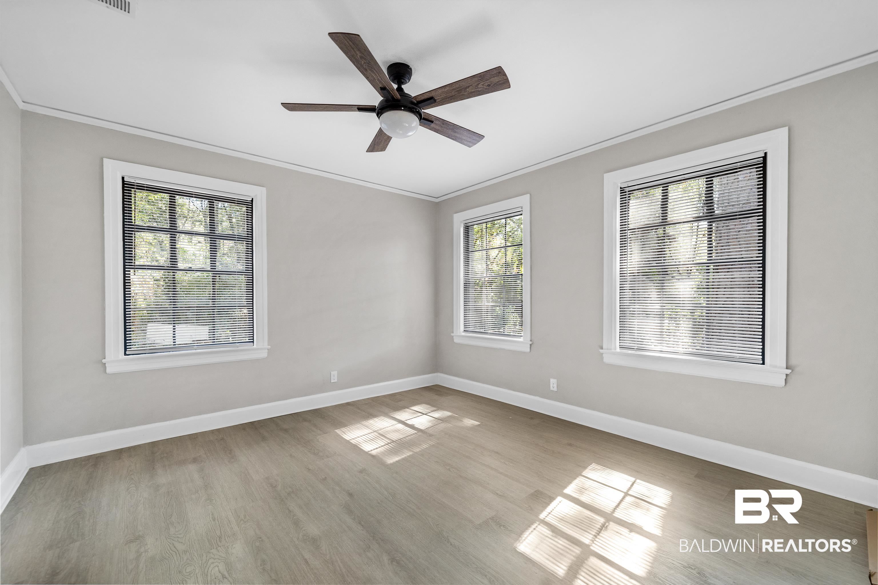611 Morgan Avenue Mobile, AL 36606 - Photo 17 of 24 Spare room with crown molding, a healthy amount of sunlight, and light wood-type flooring