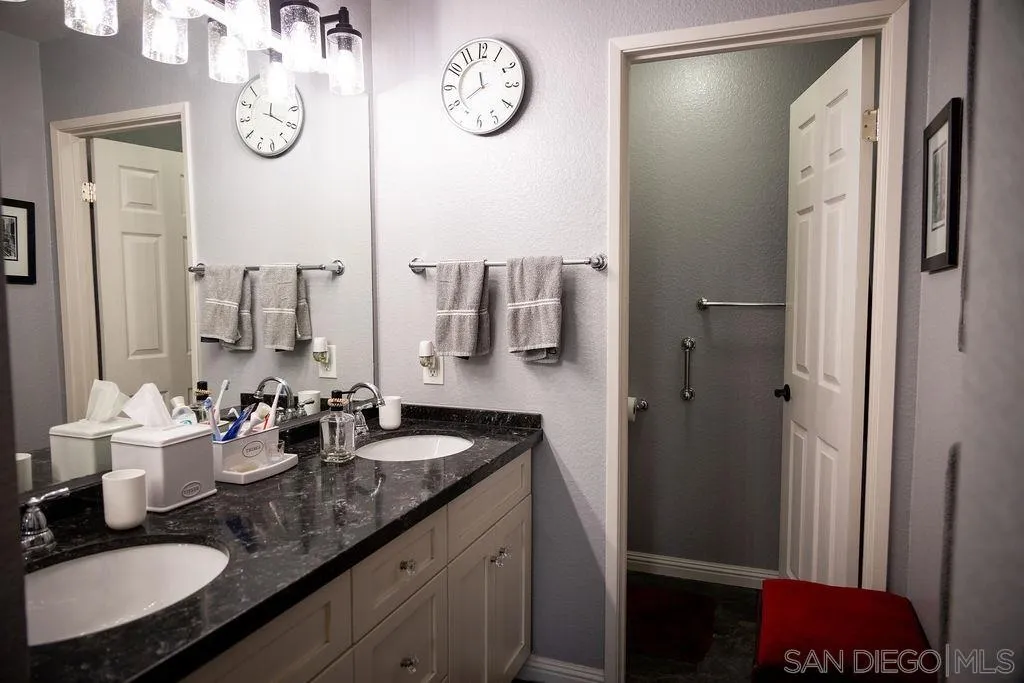 13890 Pinkard Way, Unit 68 El Cajon, CA 92021 - Photo 17 of 25 a bathroom with a granite countertop sink and a mirror
