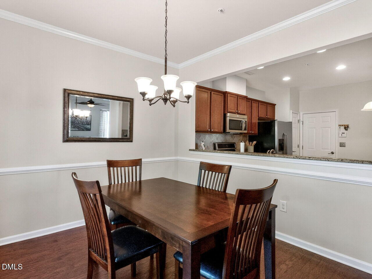 8215 Yaxley Hall Drive Raleigh, NC 27616 - Photo 13 of 42 a view of a dining room with furniture a chandelier and wooden floor