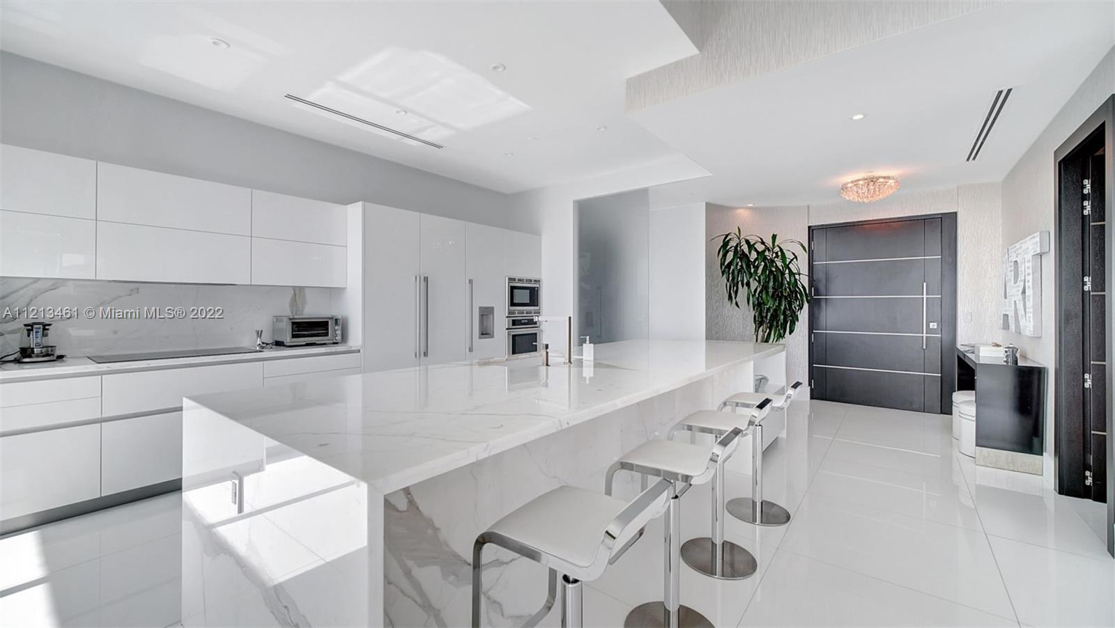 900 Brickell Key Boulevard, Unit 3103 Miami, FL 33131 - Photo 11 of 46 a large white kitchen with a sink and cabinets
