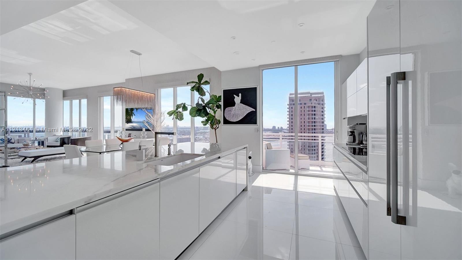 900 Brickell Key Boulevard, Unit 3103 Miami, FL 33131 - Photo 12 of 46 a large white kitchen with a large window and stainless steel appliances