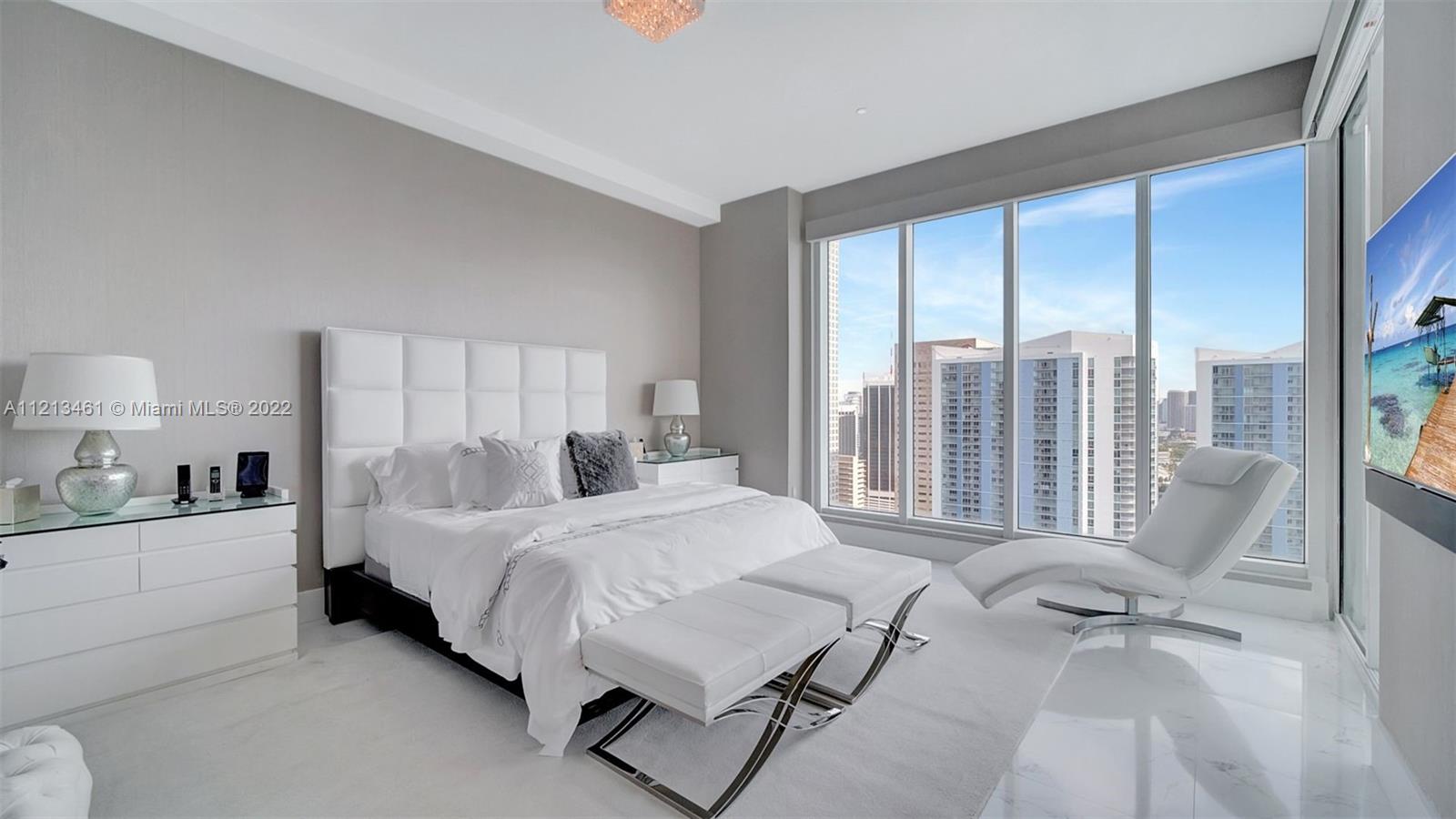 900 Brickell Key Boulevard, Unit 3103 Miami, FL 33131 - Photo 21 of 46 a bedroom with a bed and large windows
