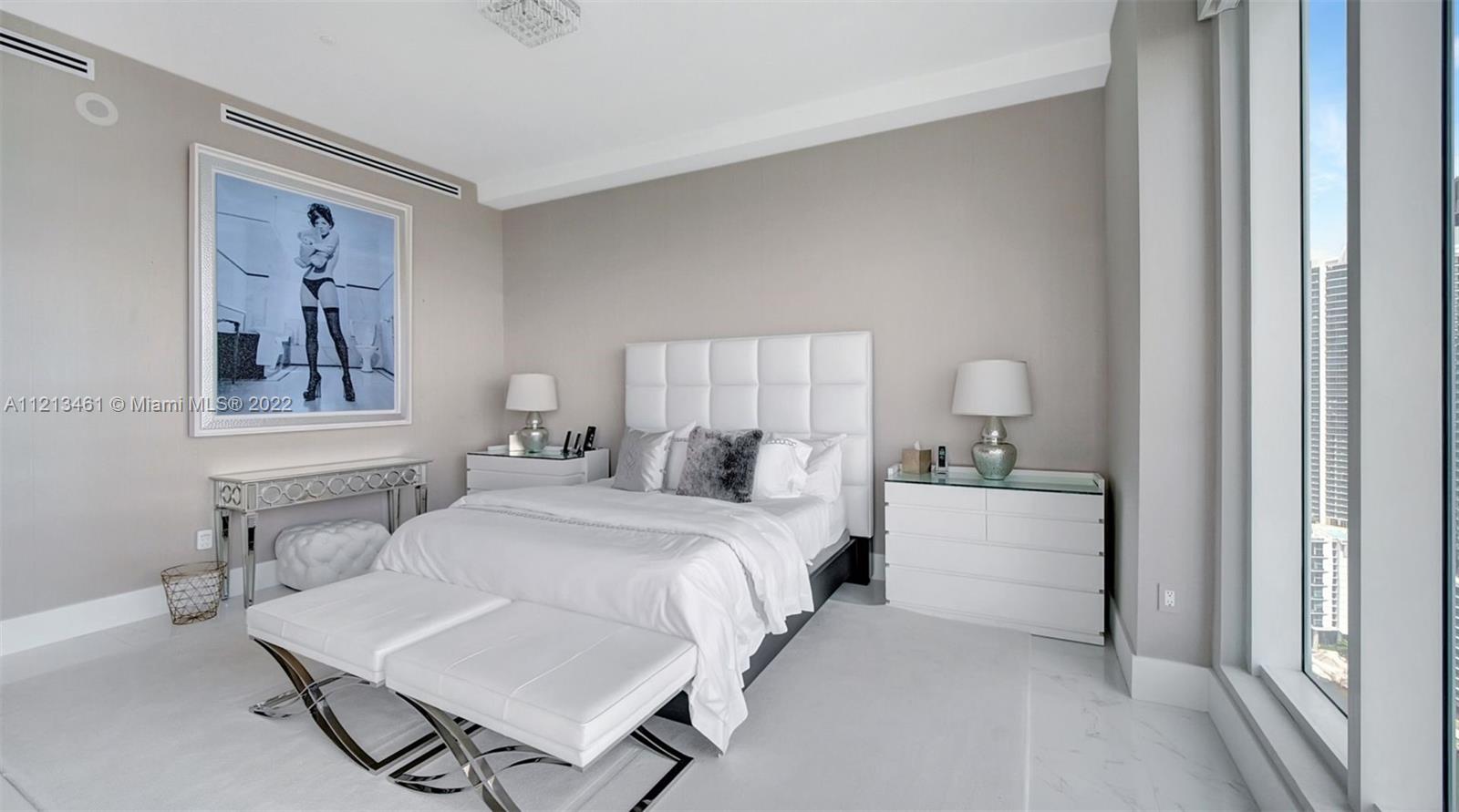 900 Brickell Key Boulevard, Unit 3103 Miami, FL 33131 - Photo 22 of 46 a bedroom with a bed and lamp
