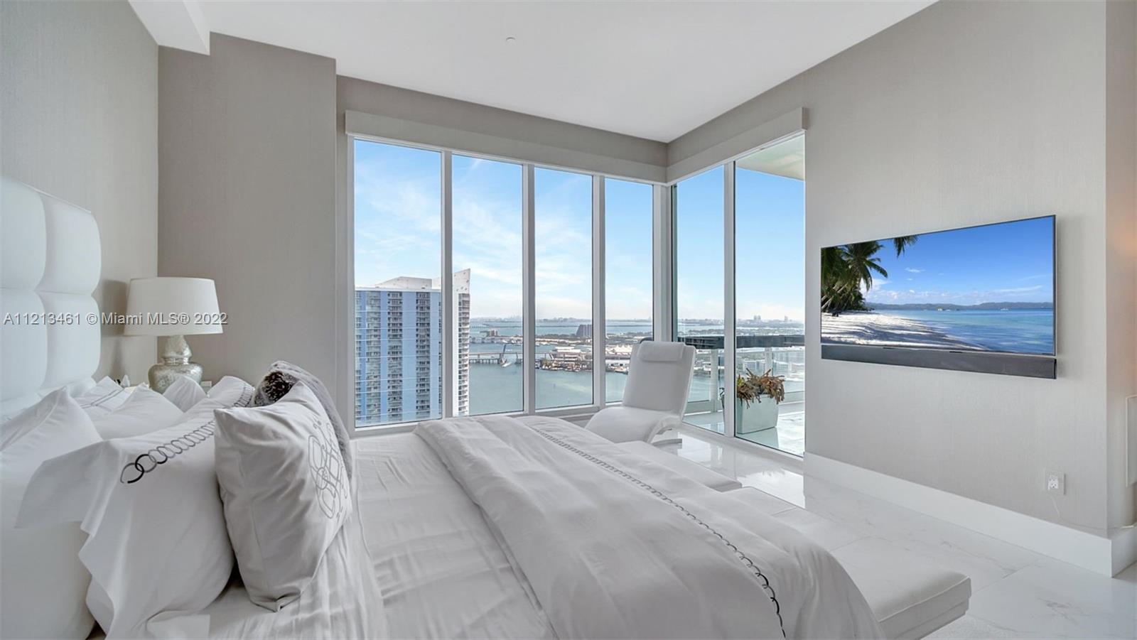 900 Brickell Key Boulevard, Unit 3103 Miami, FL 33131 - Photo 23 of 46 a bedroom with a bed and a large window