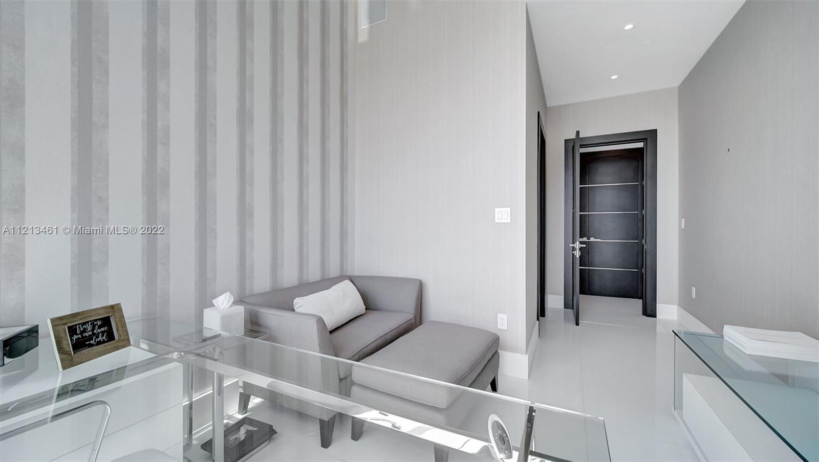 900 Brickell Key Boulevard, Unit 3103 Miami, FL 33131 - Photo 29 of 46 a living room with furniture and a flat screen tv