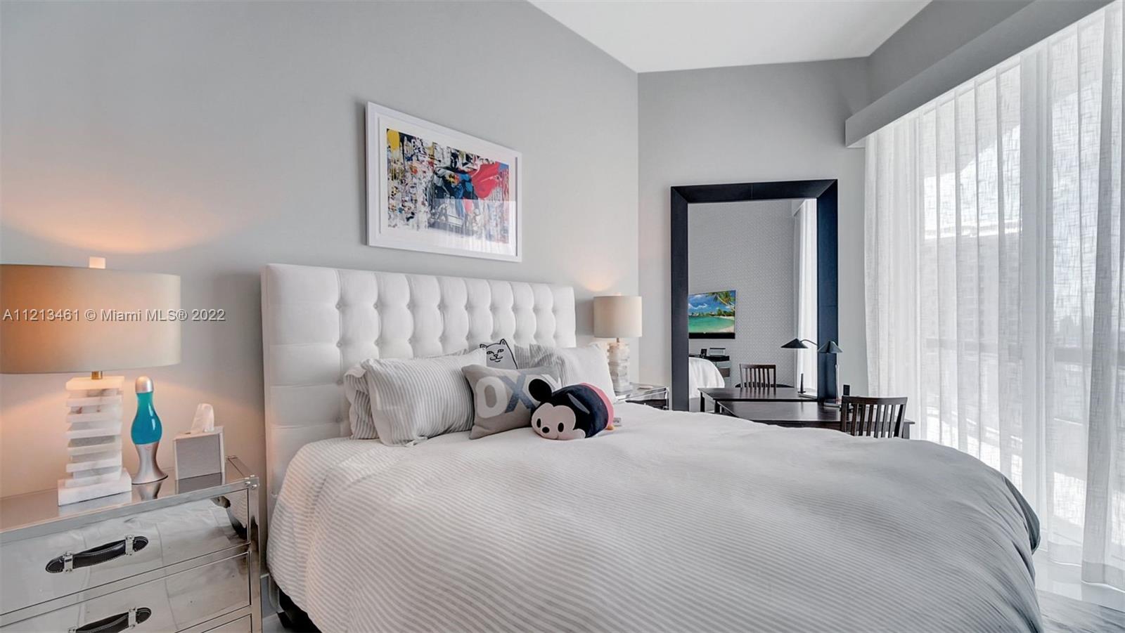 900 Brickell Key Boulevard, Unit 3103 Miami, FL 33131 - Photo 33 of 46 a bedroom with a bed and a large mirror