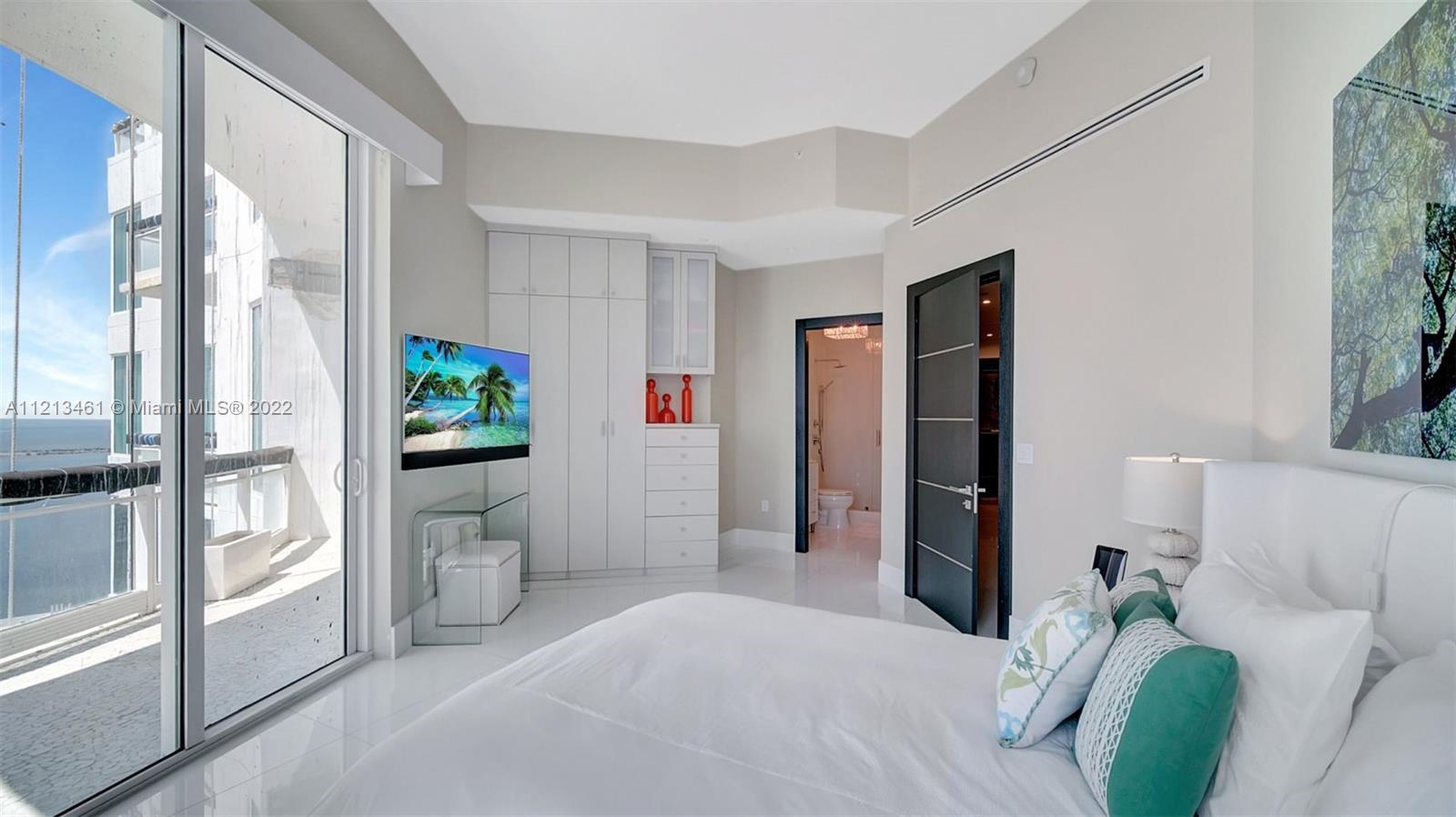 900 Brickell Key Boulevard, Unit 3103 Miami, FL 33131 - Photo 34 of 46 a bedroom with furniture and a potted plant