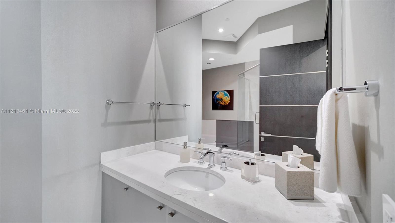 900 Brickell Key Boulevard, Unit 3103 Miami, FL 33131 - Photo 36 of 46 a bathroom with a sink and a mirror