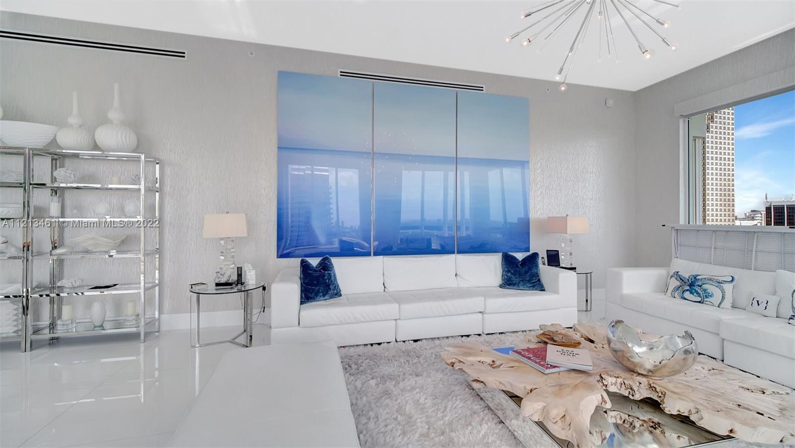 900 Brickell Key Boulevard, Unit 3103 Miami, FL 33131 - Photo 4 of 46 a living room with furniture and a chandelier