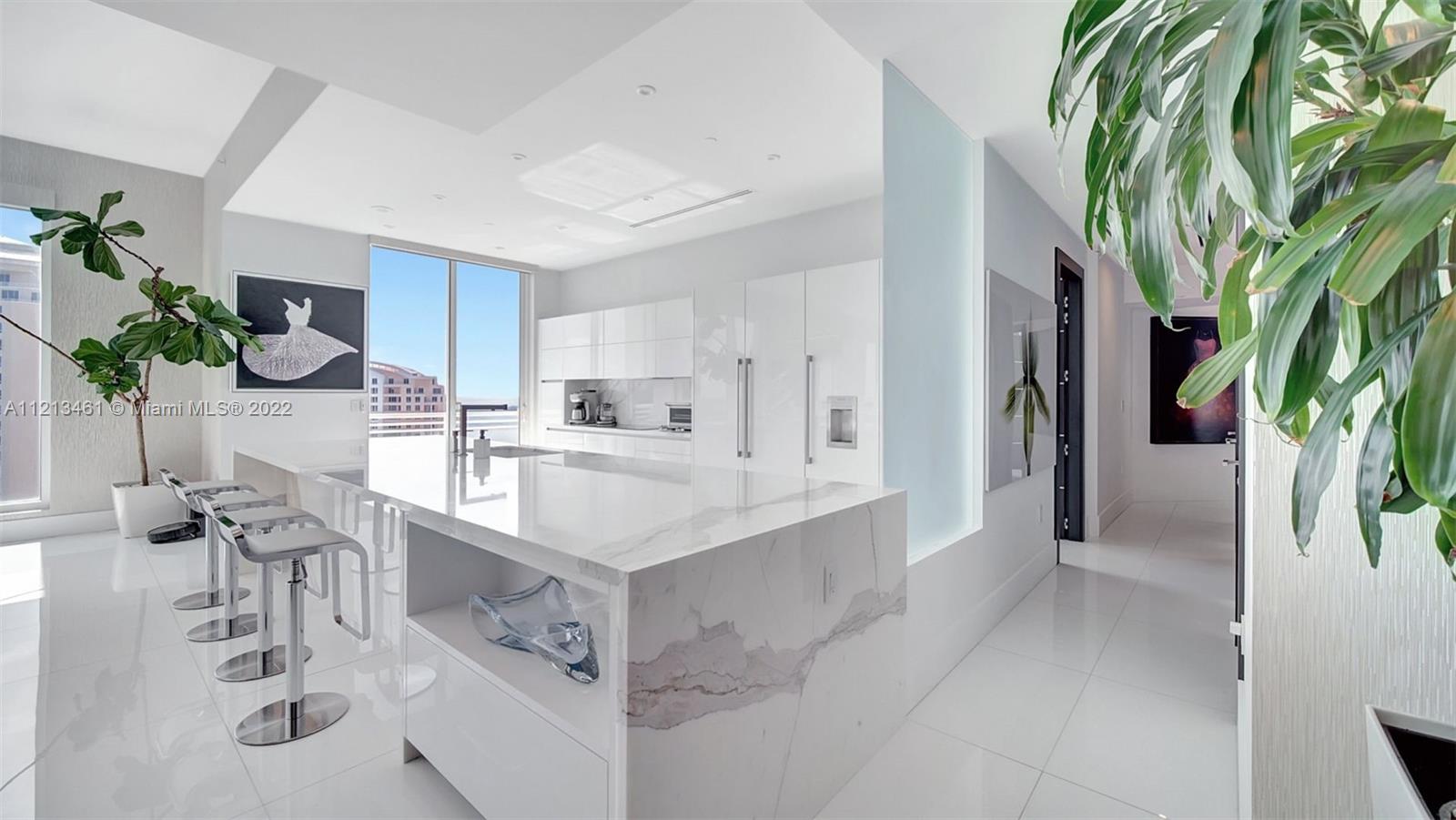 900 Brickell Key Boulevard, Unit 3103 Miami, FL 33131 - Photo 10 of 46 a white kitchen with cabinets and furniture