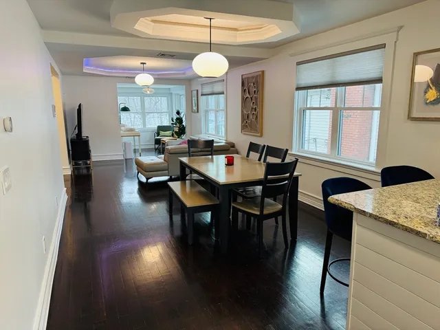 a view of a a dining room with furniture window and wooden floor