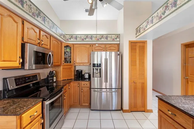 a kitchen with stainless steel appliances granite countertop a refrigerator and a stove top oven