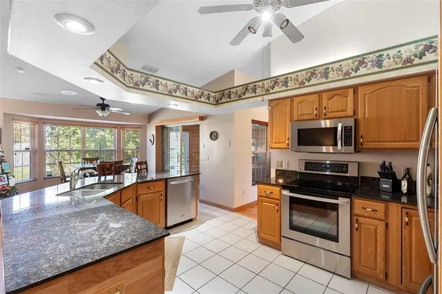 a kitchen with stainless steel appliances granite countertop a stove a sink and a microwave